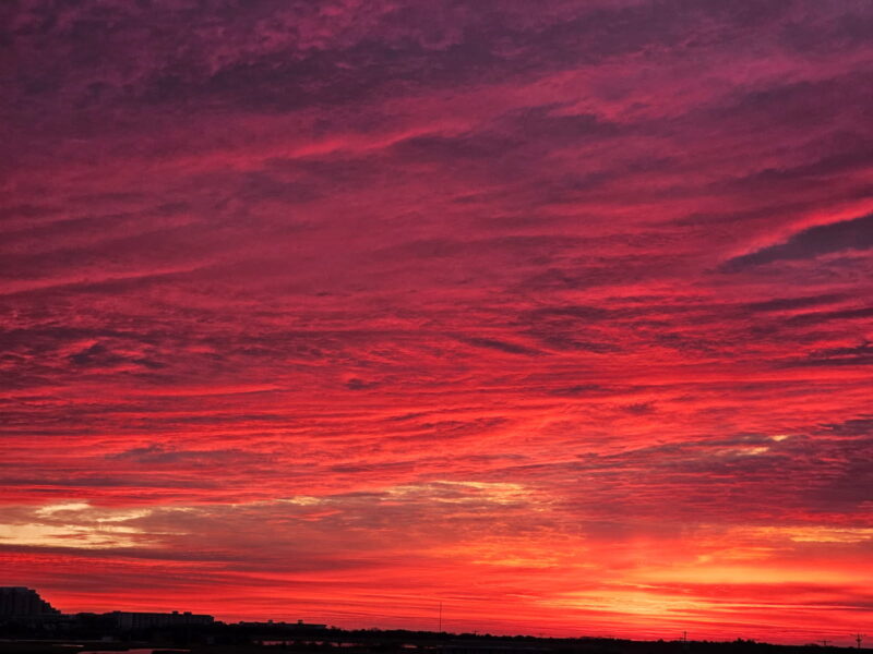 Purple & Pink tinted clouds illuminate the Horizon of Cape May City from the view of the Wildwood Crest Bridge